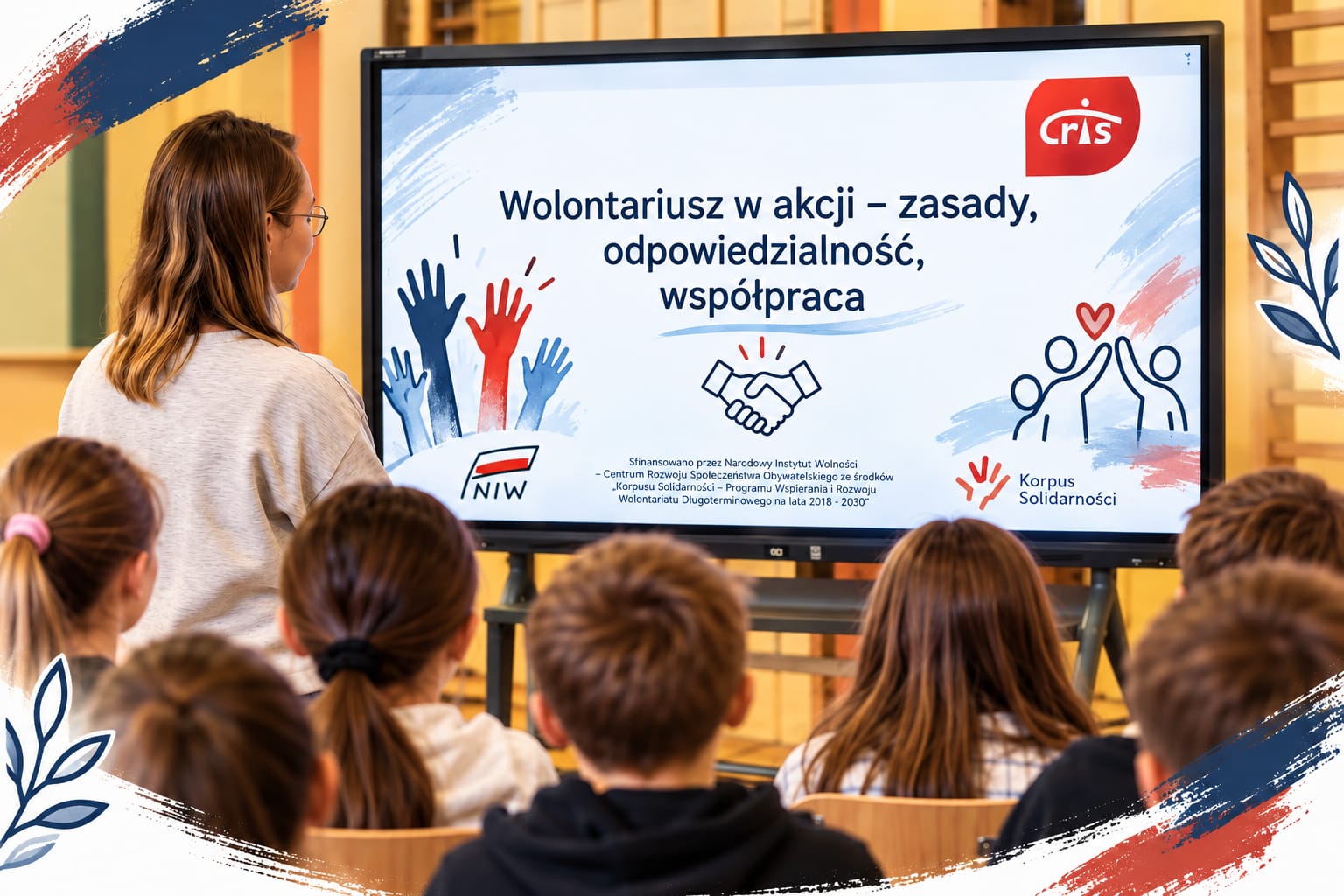 Uczniowie uczestniczą w zajęciach edukacyjnych „Wolontariusz w akcji – zasady, odpowiedzialność, współpraca”. Prezentacja na tablicy multimedialnej dotyczy idei wolontariatu, współdziałania i odpowiedzialnej pomocy innym.